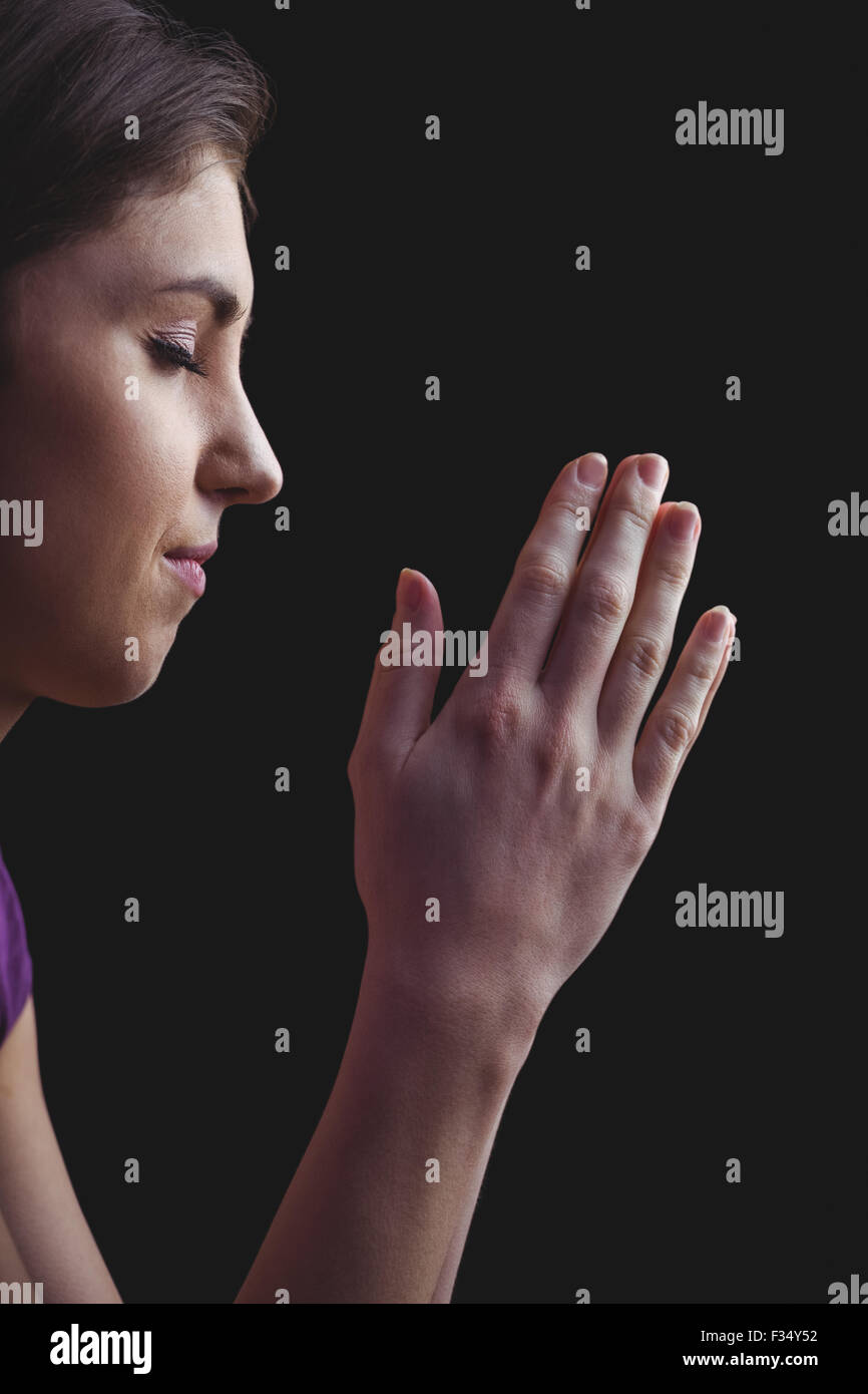 Woman praying with hands together Stock Photo