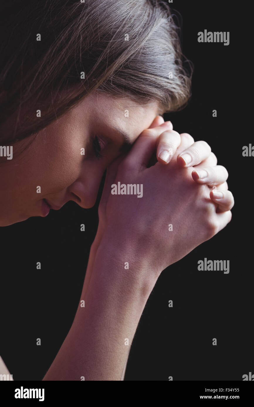 Woman praying with hands together Stock Photo