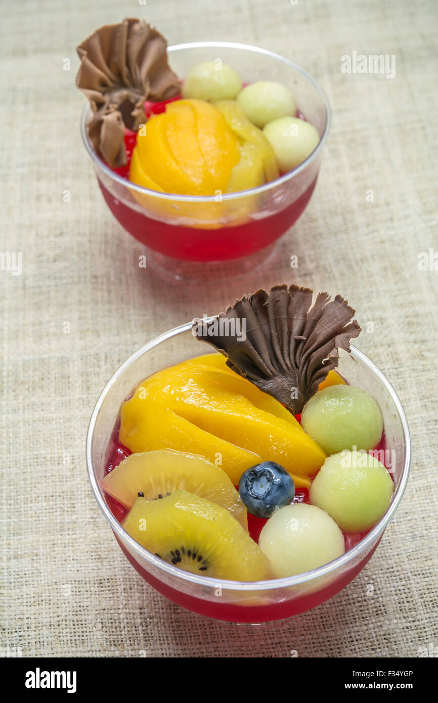 red jelly with colorful fruit on bark background Stock Photo