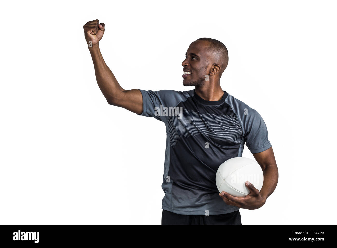 Sportsman with clenched fist holding rugby ball after victory Stock