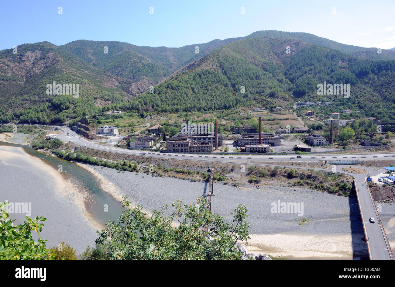 Derelict factories outside the town of Rubik and a bridge over the River Fani. Stock Photo