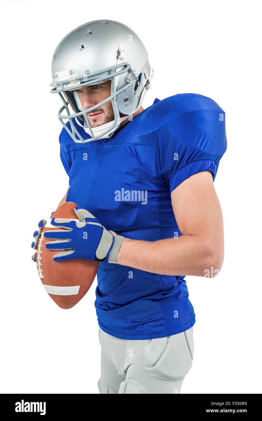 American football player holding ball while looking away Stock Photo