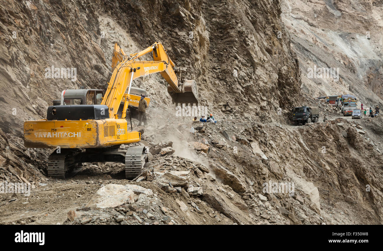Excavator from Border Roads Organization and GREF clears hazardous Himalayan mountain road following landslide Stock Photo