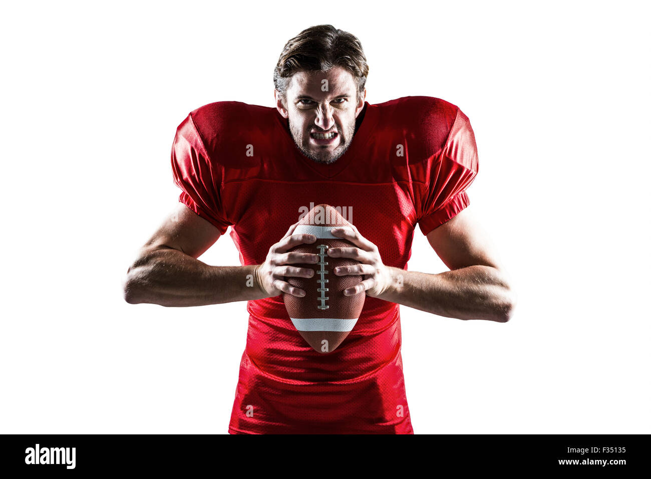 Angry American football player in red jersey holding ball Stock Photo -  Alamy