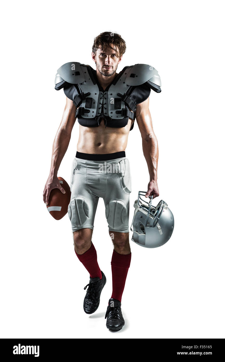 Shirtless American football player with padding holding ball and helmet
