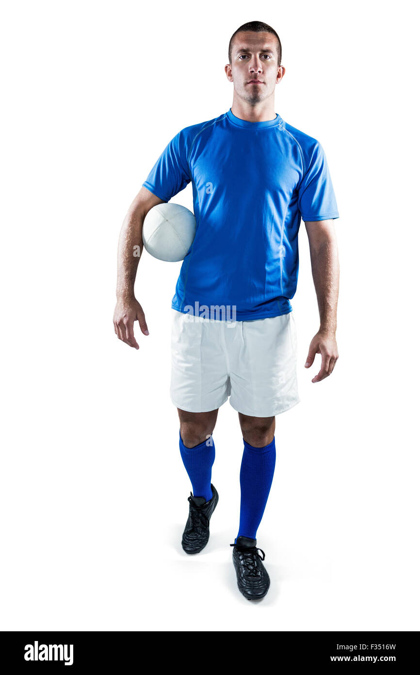 Portrait of rugby player looking away while holding ball aside Stock Photo