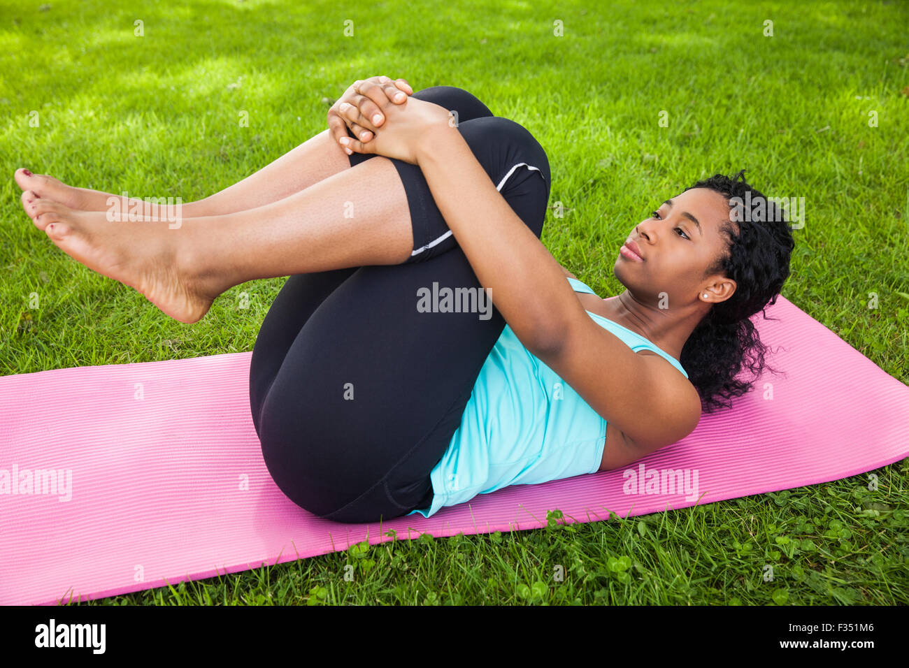 Young woman doing pilates on mat Stock Photo