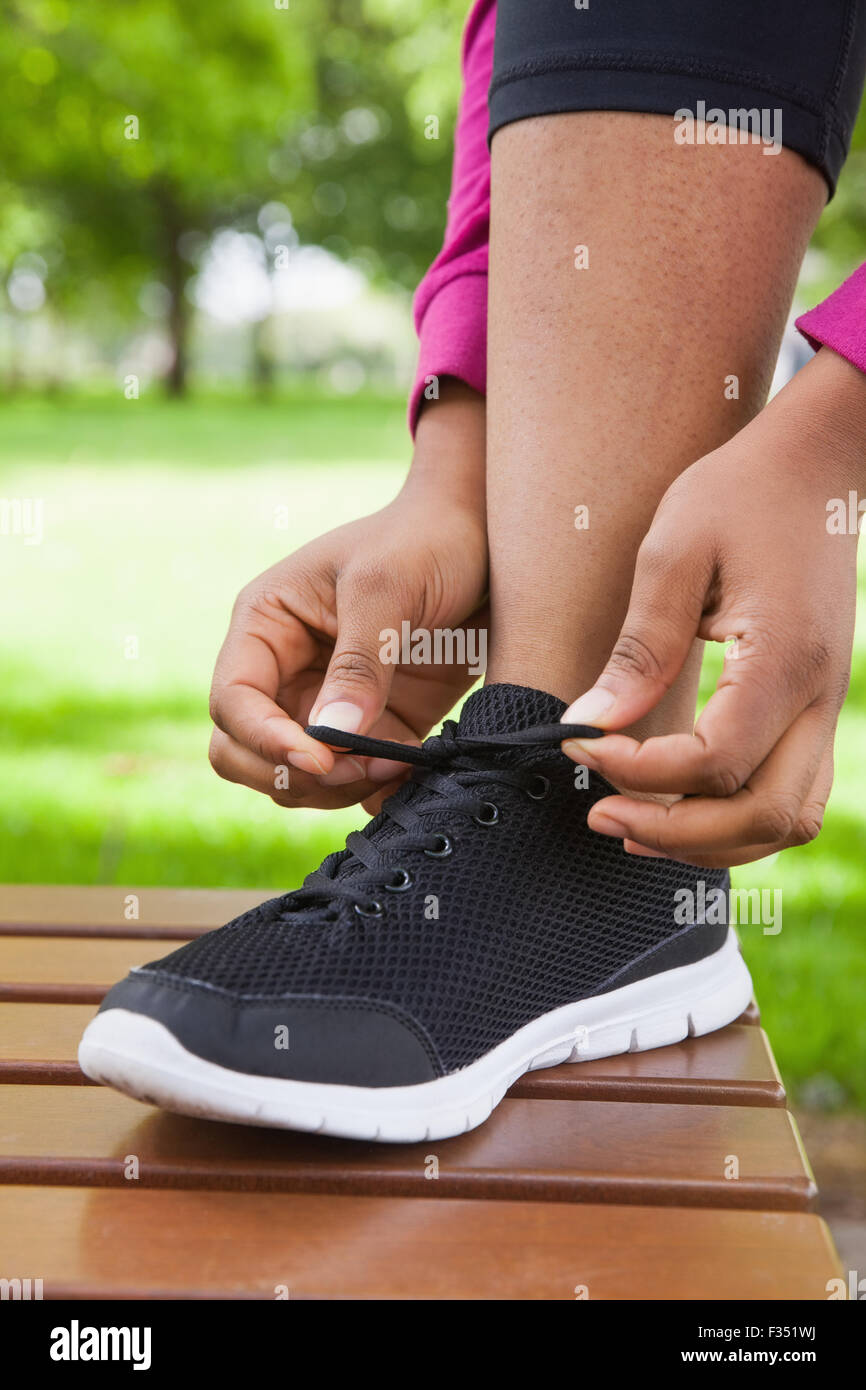 Woman tying her shoelace on running shoe Stock Photo