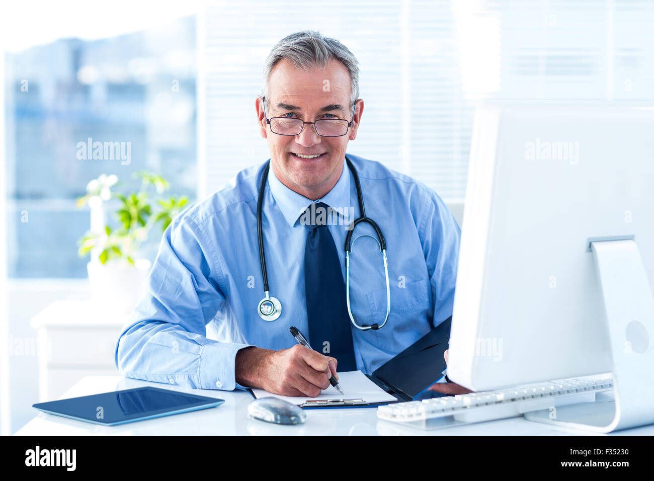 Portrait of smiling male doctor with document in hospital Stock Photo ...