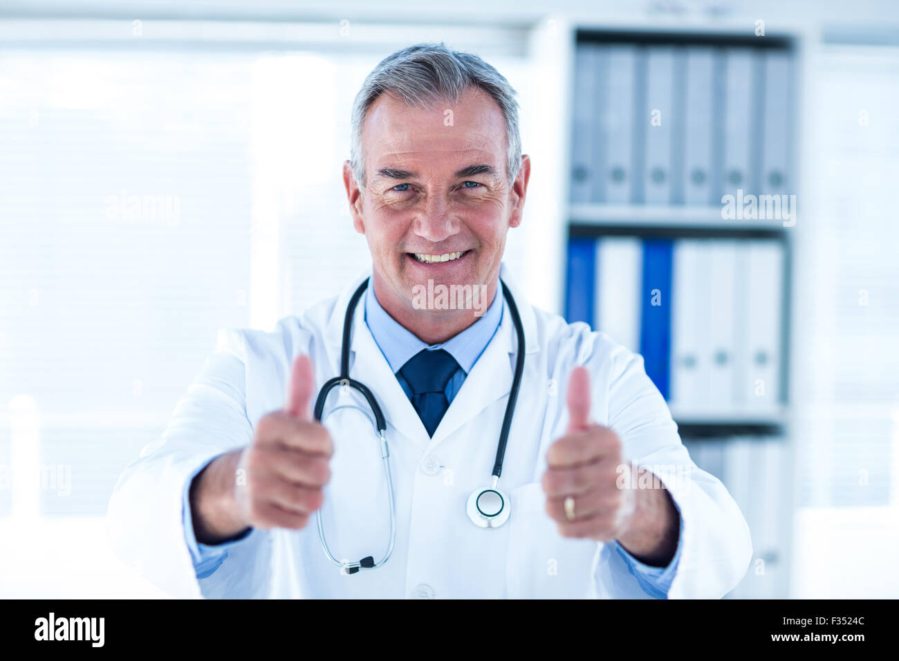 Portrait of doctor showing thumps up sign in clinic Stock Photo