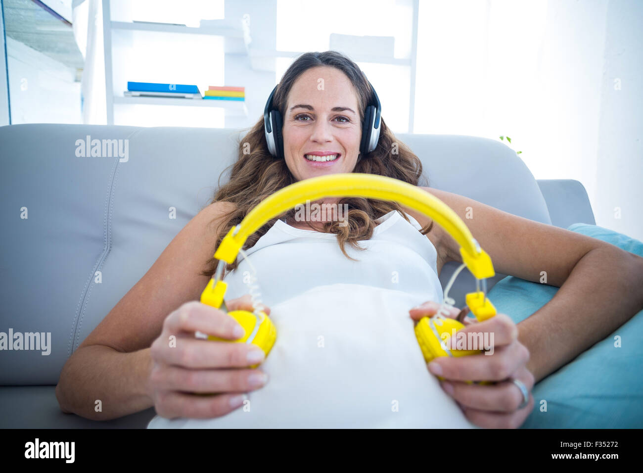 Pregnant woman listening to music at home Stock Photo - Alamy