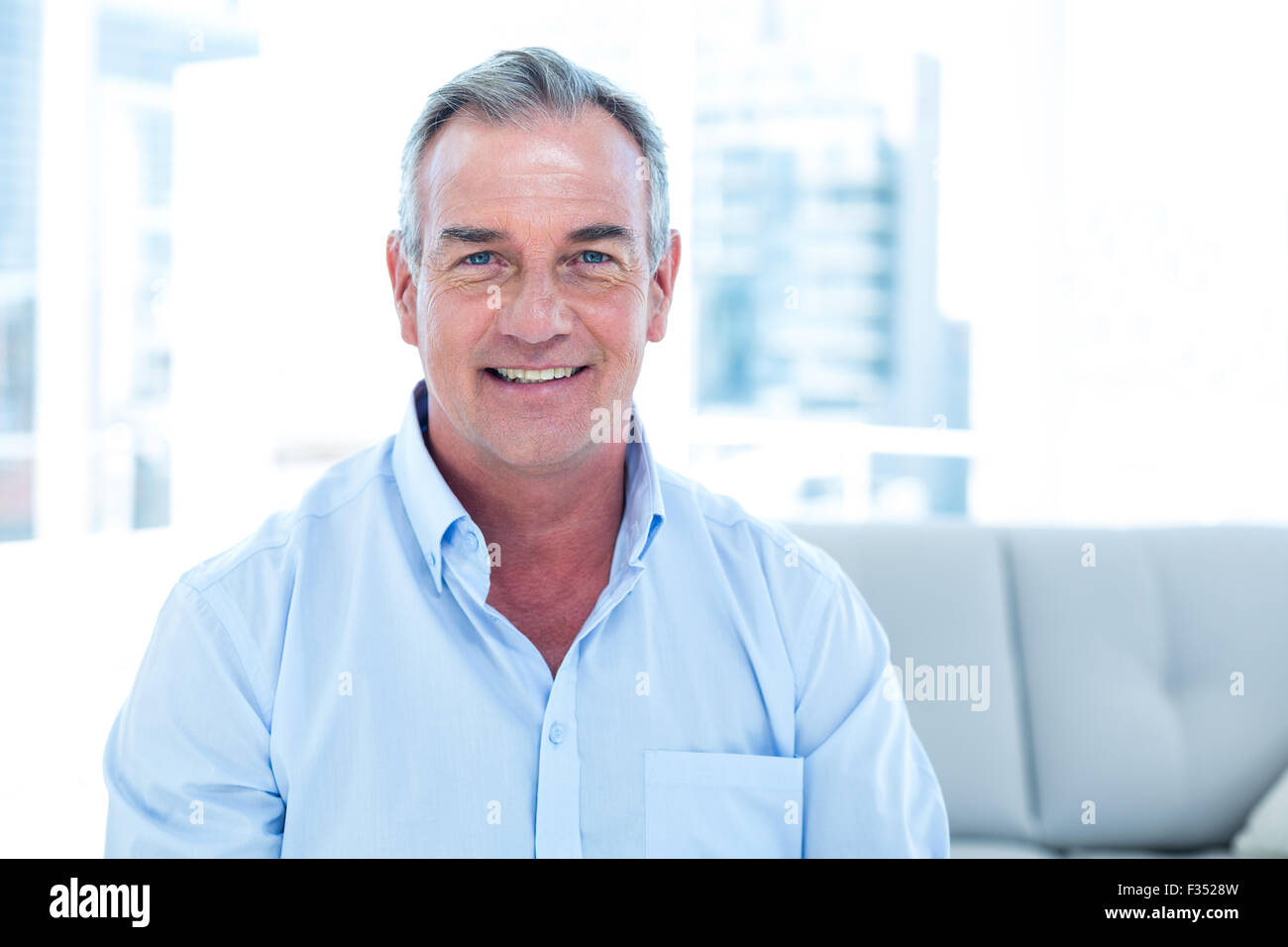 Smiling man sitting at home Stock Photo - Alamy