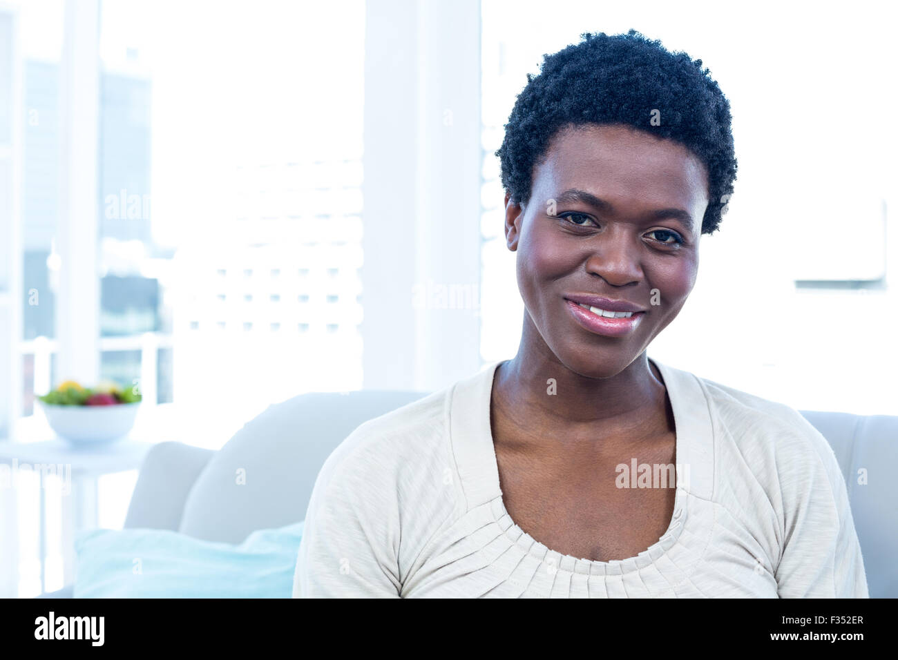Happy woman sitting in living room Stock Photo - Alamy