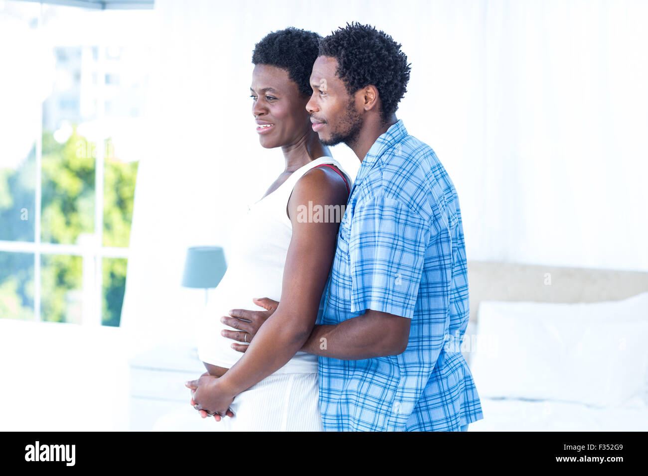 Husband embracing pregnant woman Stock Photo