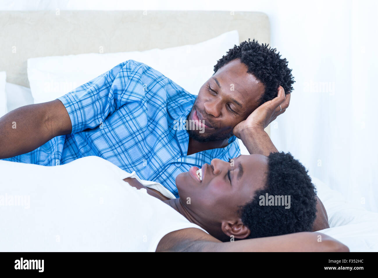 Delighted pregnant woman lying on bed Stock Photo