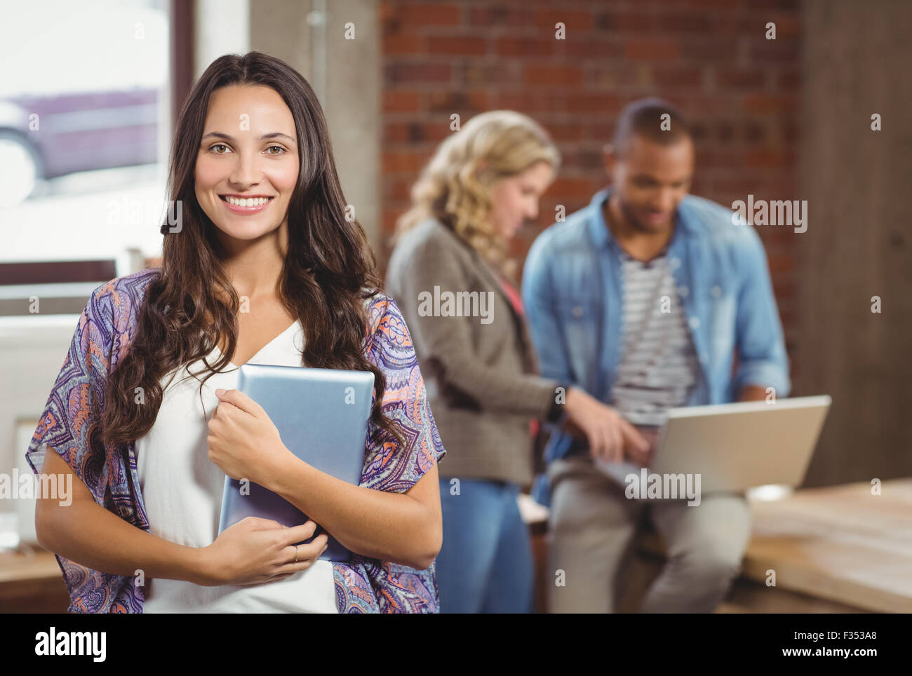 Portrait of smiling woman holding digital tablet Stock Photo - Alamy