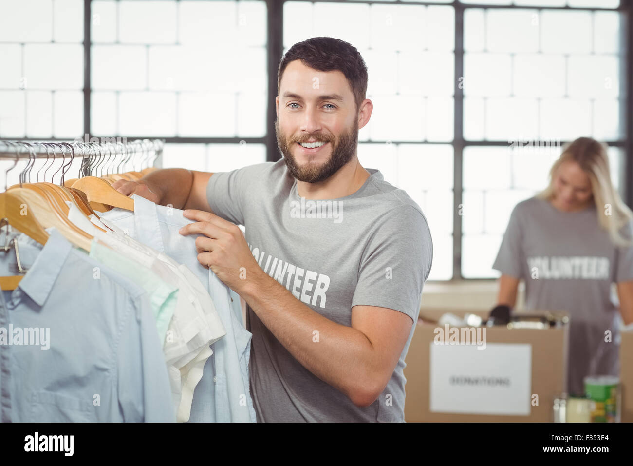 Portrait of happy man choosing clothes for donation Stock Photo