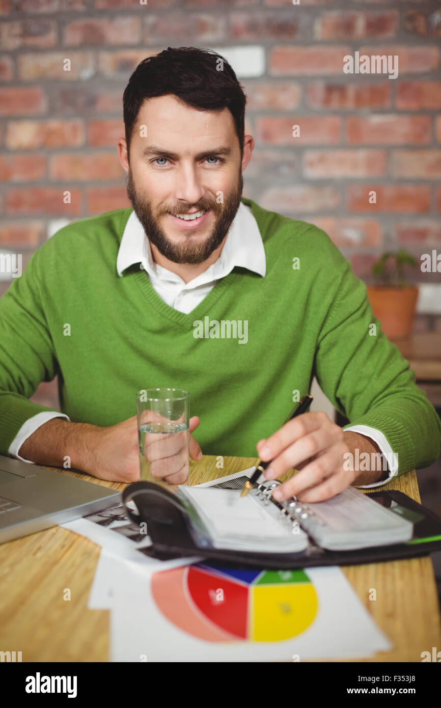 Portrait of smiling businessman writing in diary Stock Photo - Alamy