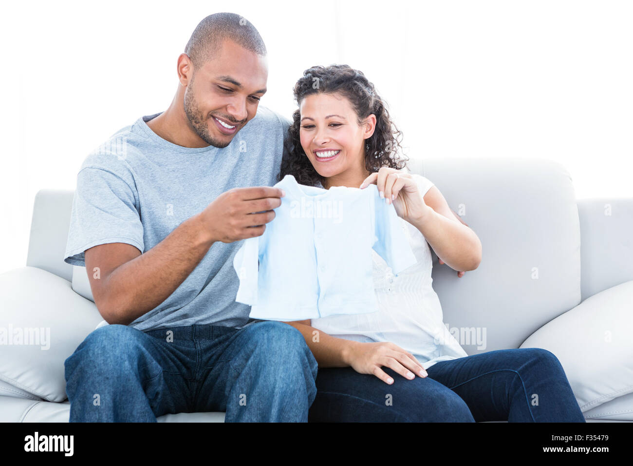 Couple looking at baby clothing Stock Photo