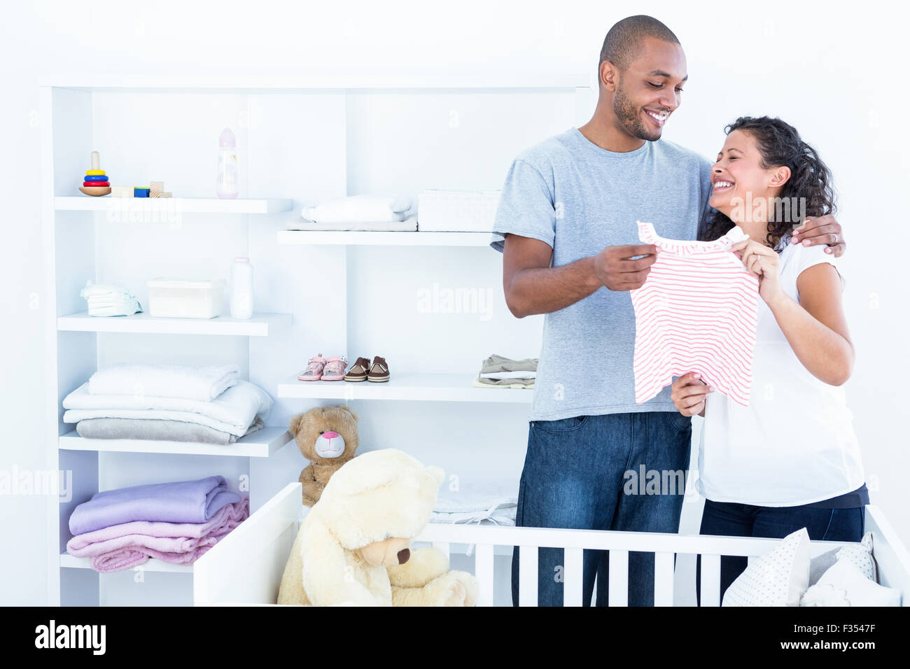 Cheerful couple holding baby clothing Stock Photo