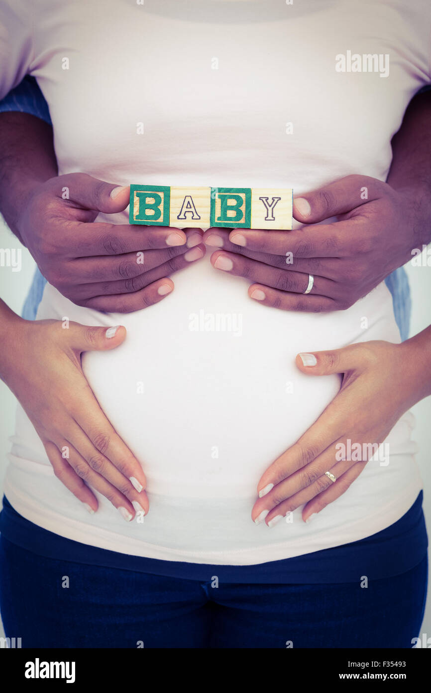 Midsection of man with wife holding baby text Stock Photo