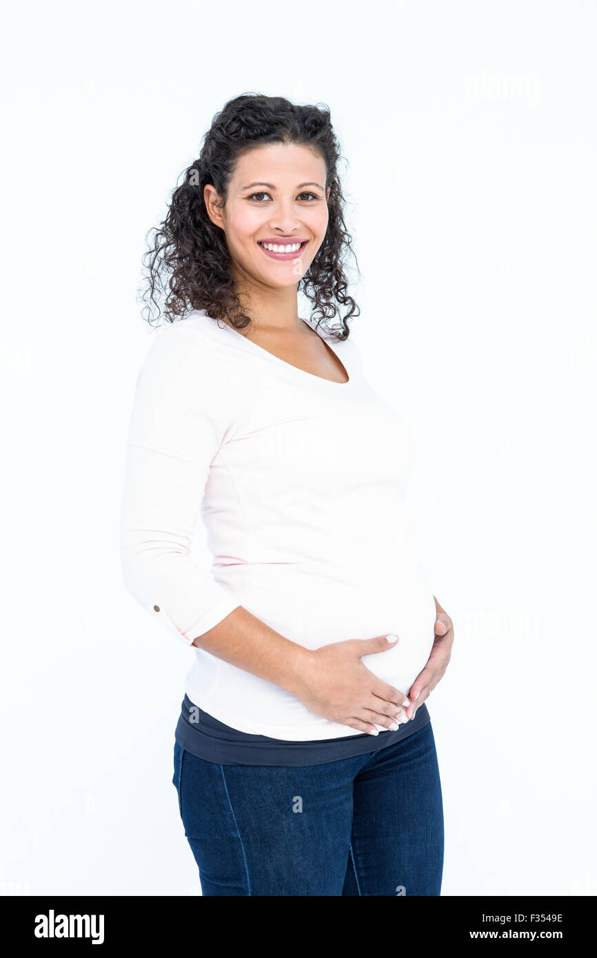 Portrait of happy pregnant woman touching abdomen Stock Photo