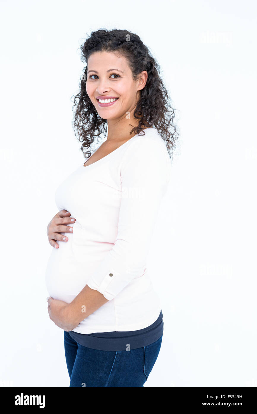 Portrait of happy pregnant woman holding abdomen Stock Photo
