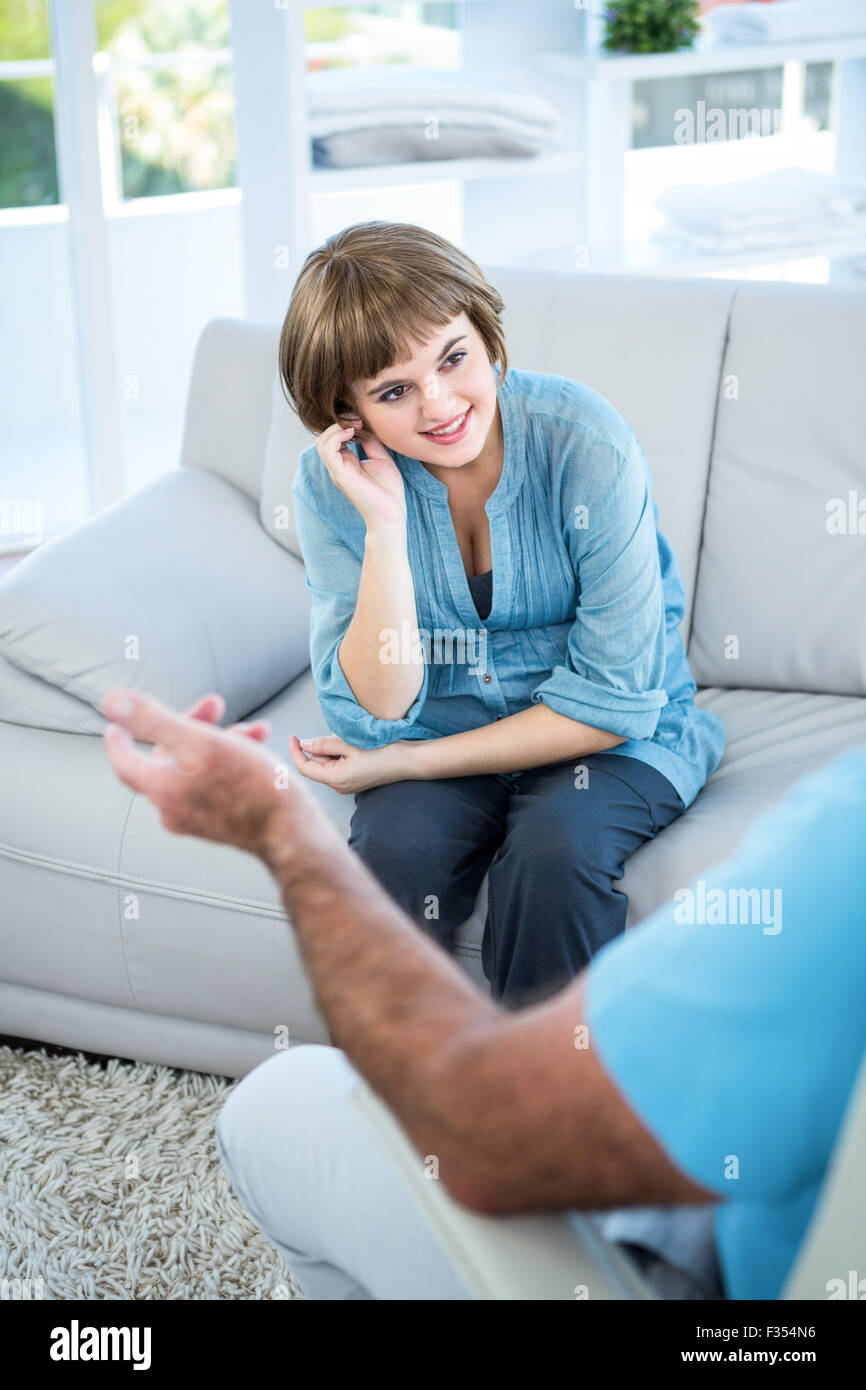 Smiling beautiful woman sitting on sofa Stock Photo - Alamy