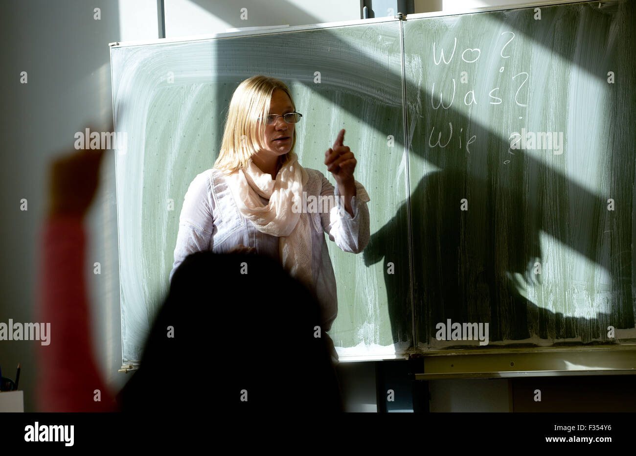 Hanover, Germany. 23rd Sep, 2015. Teacher of a language class, Miriam Frehe, stands in front of a blackboard during class at Peter-Ustinov-Schule in Hanover, Germany, 23 September 2015. 19 boys and girls from age 10 to 16 participate in the class. After one year the students are supposed to speak German well enough to get into a regular school class. PHOTO: PETER STEFFEN/DPA/Alamy Live News Stock Photo