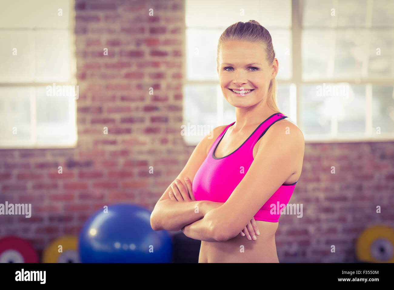 Smiling muscular woman arms crossed hi-res stock photography and