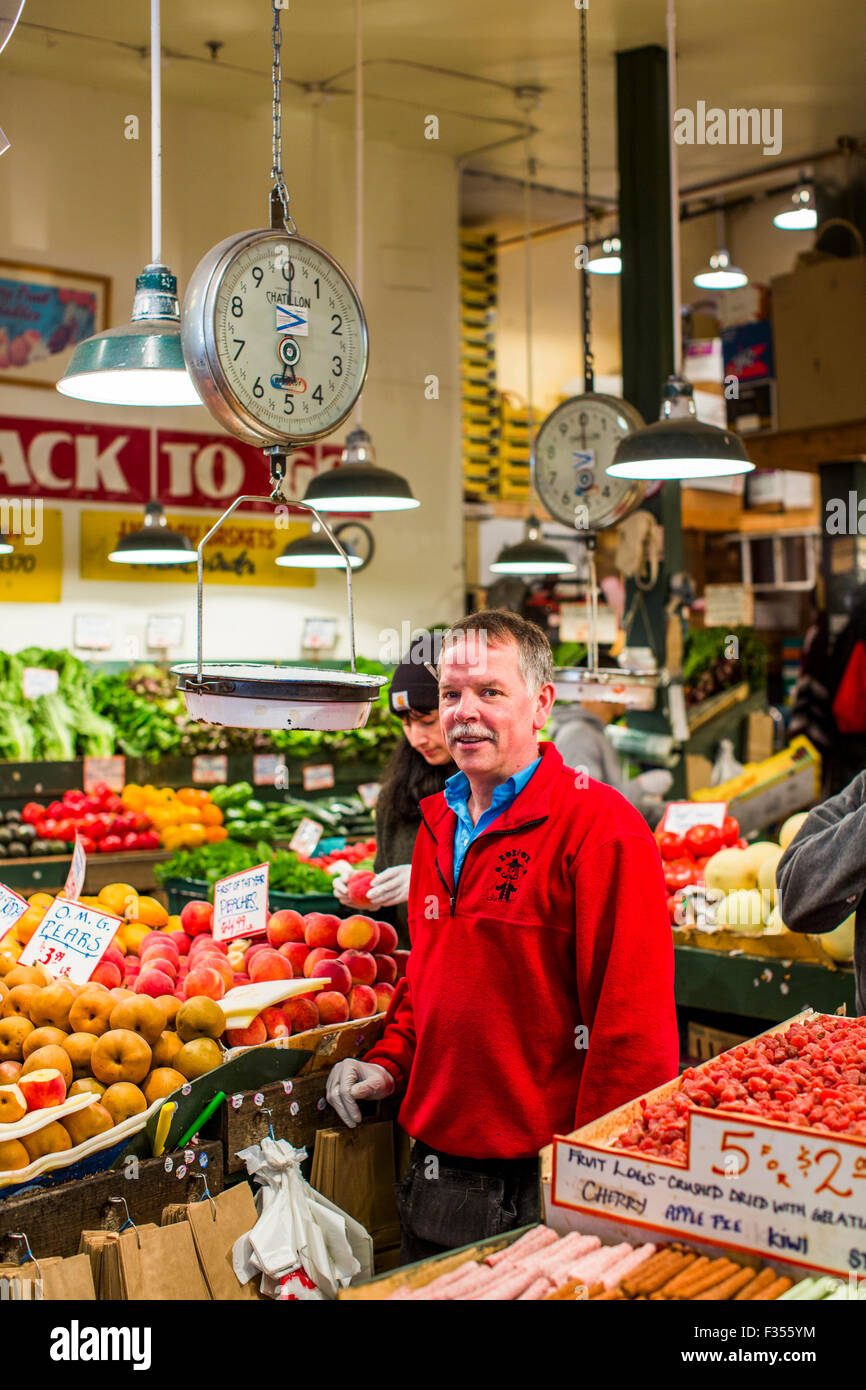 A vendor at his fresh fruit stand in Pike Place Market in Seattle, WA