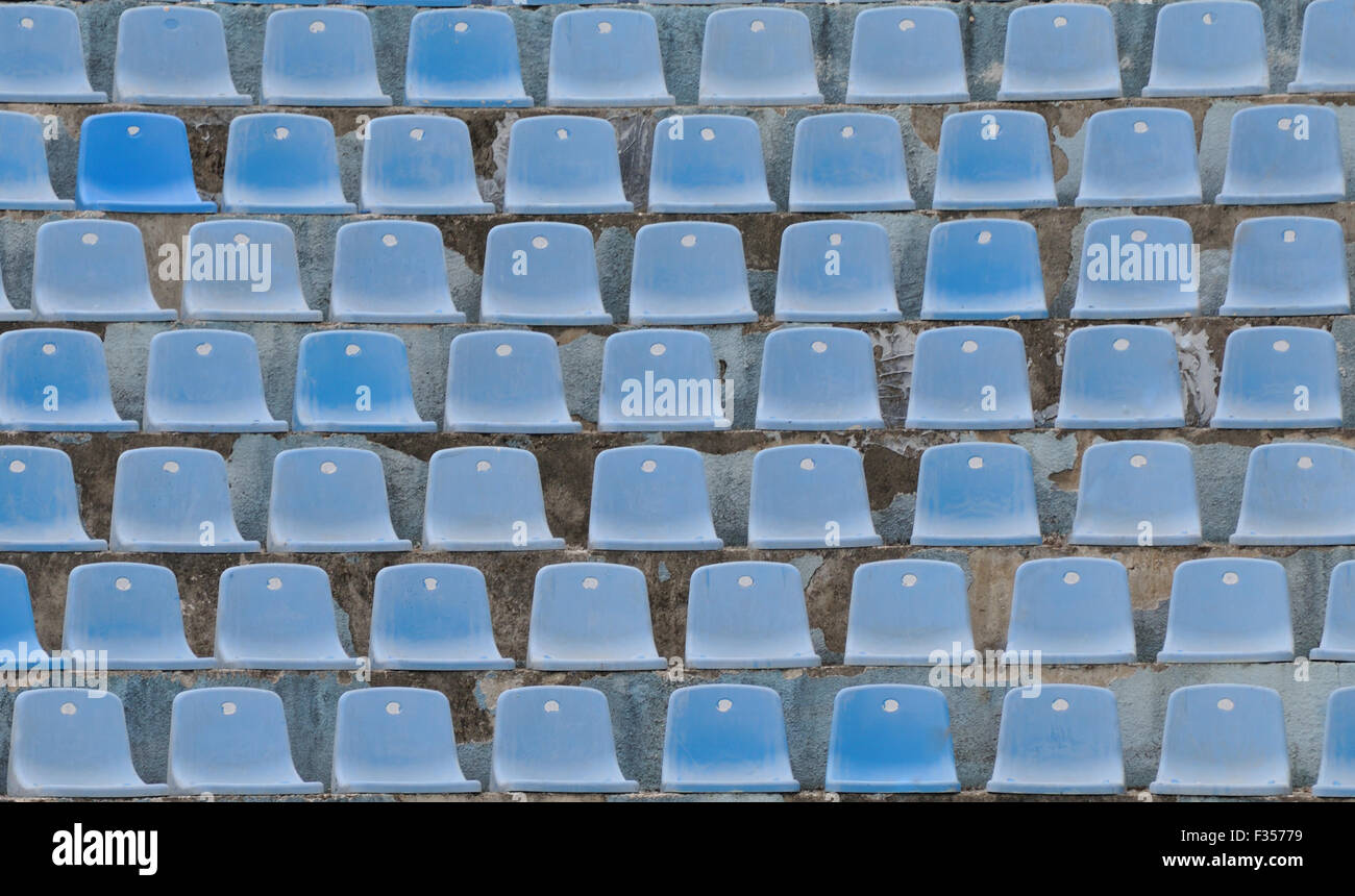 Rows of faded blue plastic seats an an outdoor arena.  Dëshmorët e Kombit Boulevard, Tirana, Albania. Stock Photo