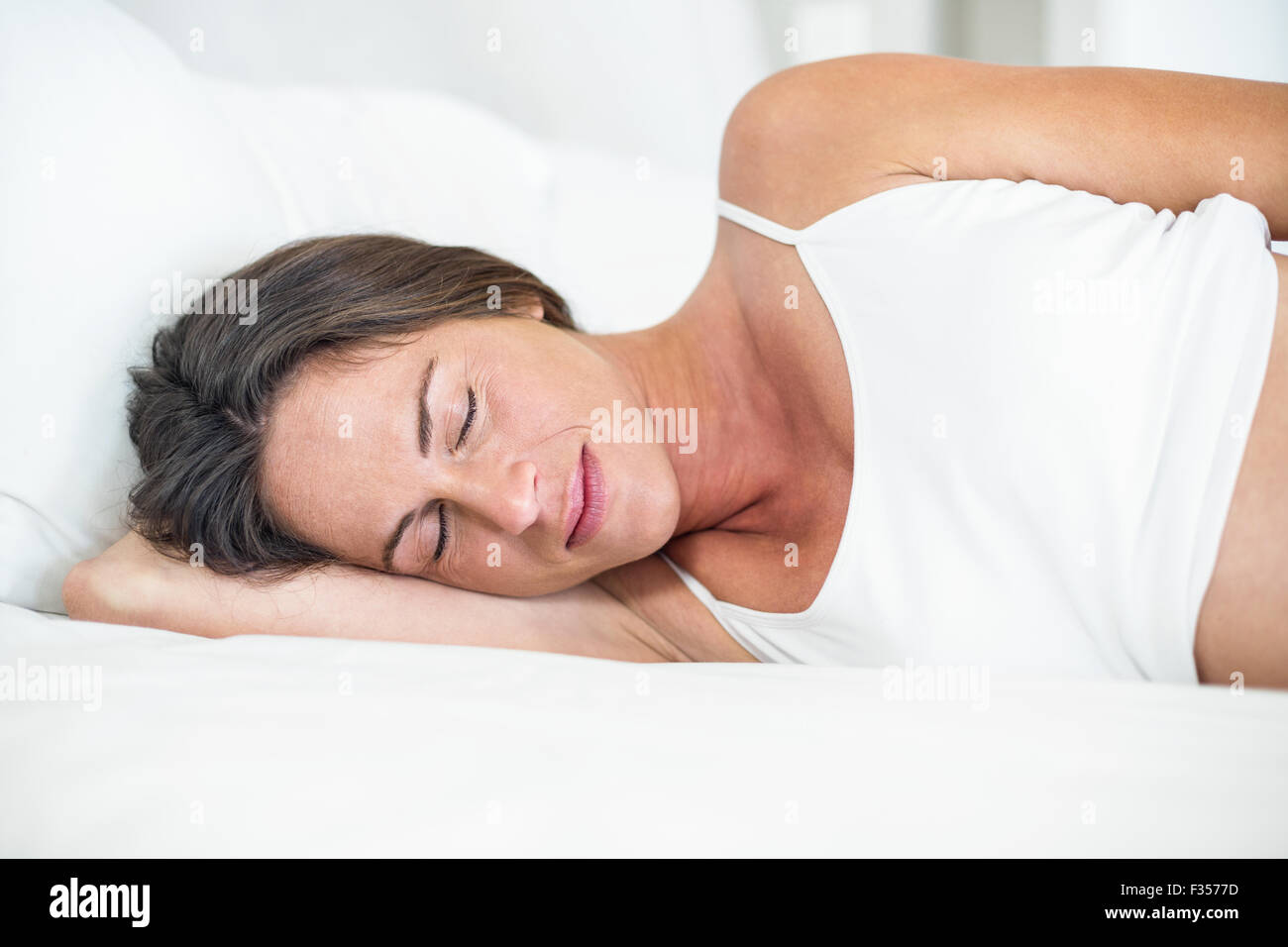 Happy woman sleeping on bed Stock Photo