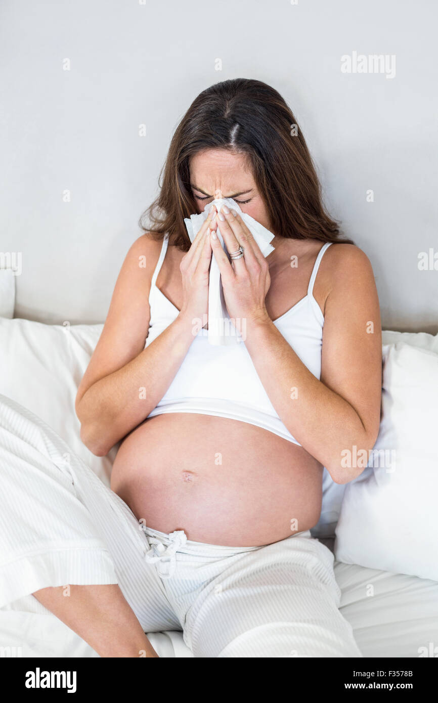 Woman blowing nose in tissue Stock Photo