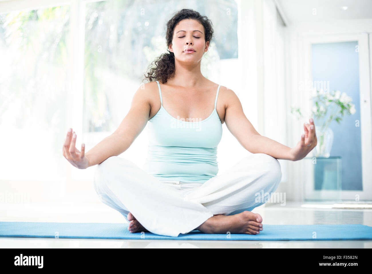 Pregnant woman doing yoga with eyes closed on exercise mat Stock Photo Alamy