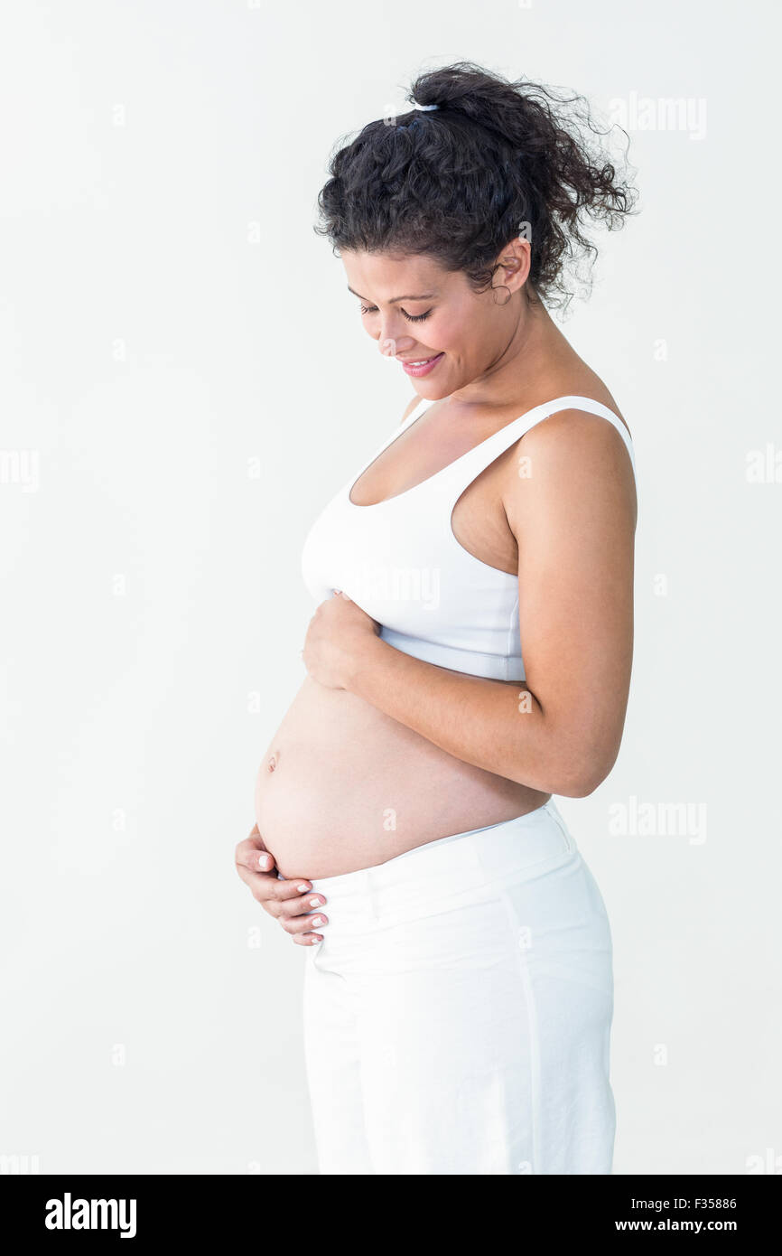 Smiling pregnant woman touching tummy Stock Photo