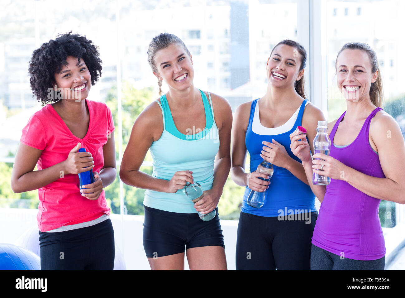 Portrait of fit women holding water bottle Stock Photo - Alamy