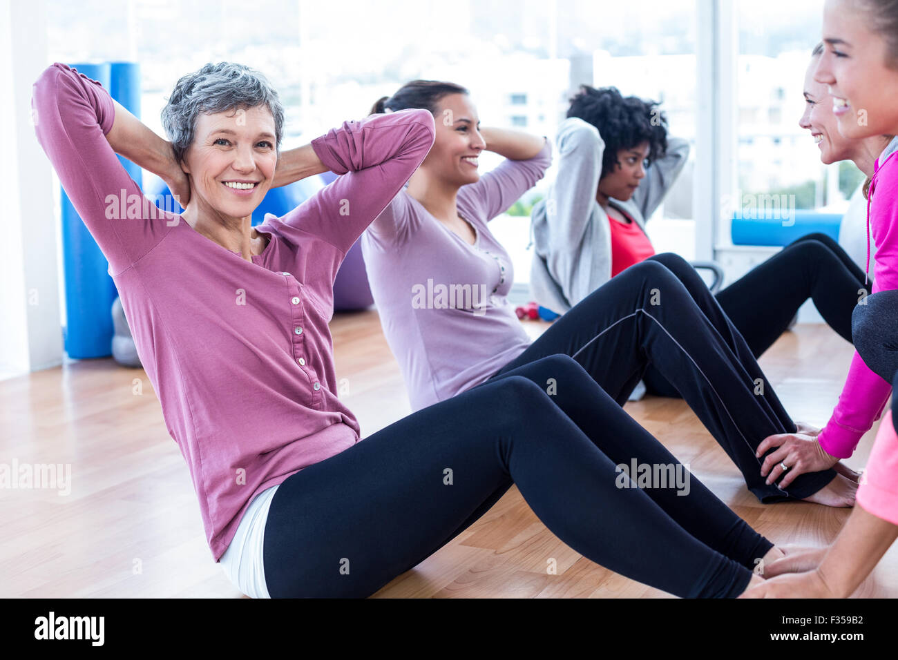 Fit pretty young woman wearing black top and leggings doing yoga stretching  exercises in fitness training white gym loft classroom. Sport healthy life  Stock Photo - Alamy