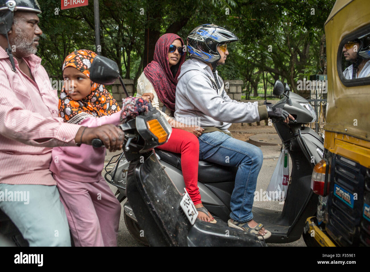 Scooter drivers and passengers, Bengaluru, Karnataka, India Stock Photo