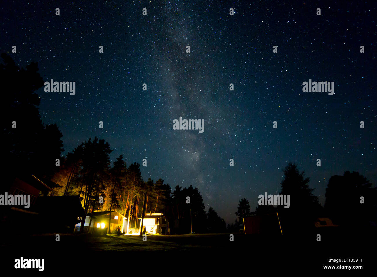 Night starry sky scene with milky way and lights of cottages Stock ...