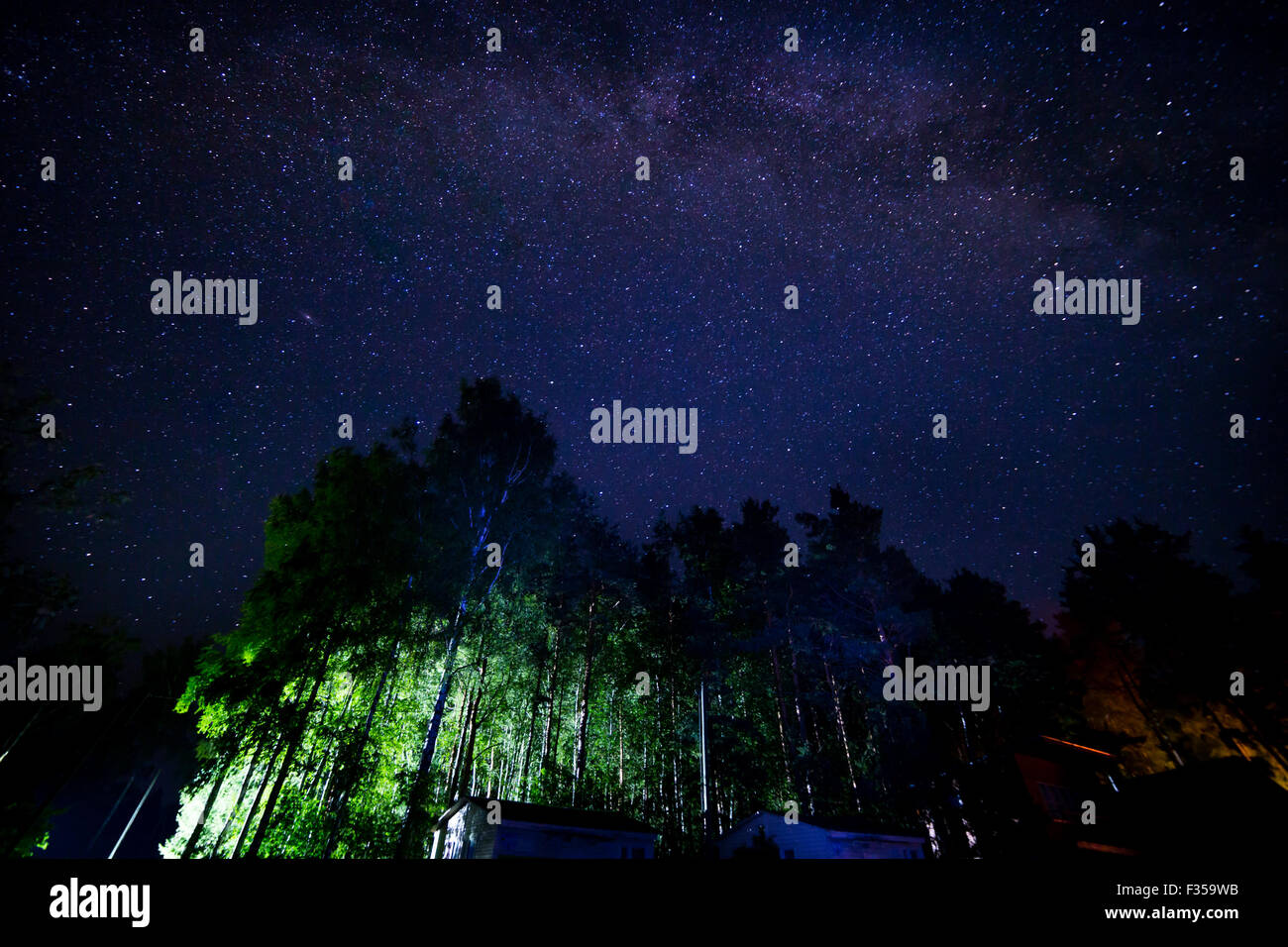 Night starry sky scene with milky way and lights of cottages Stock ...