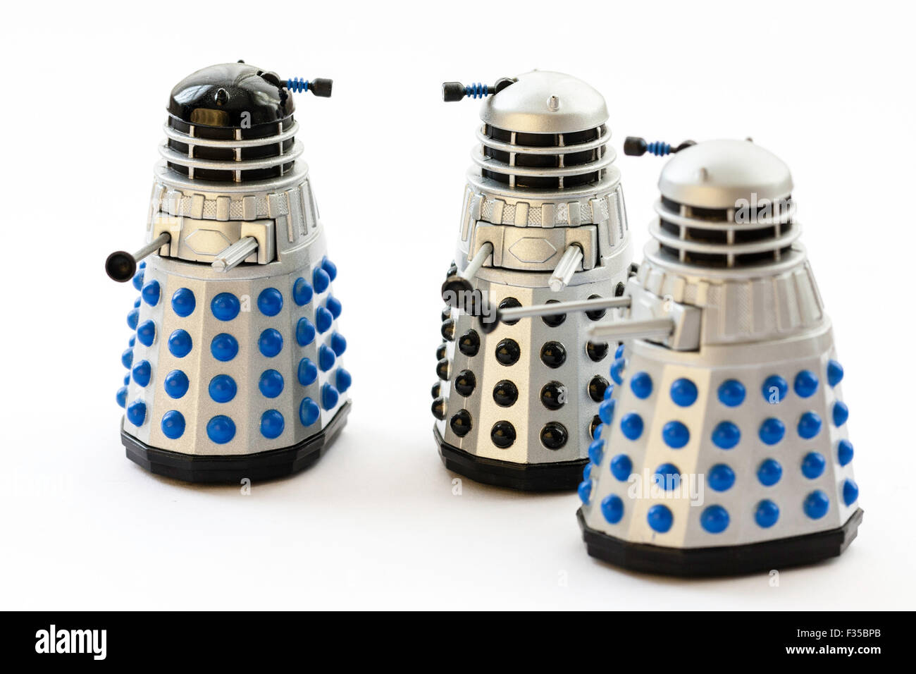 Daleks from the BBC Dr Who TV series. Famous metal monster. Corgi toy, metal Dalek with turning head. Three various types on plain white background. Stock Photo