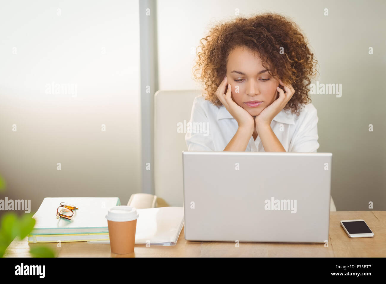 Businesswoman with hand on chin Stock Photo
