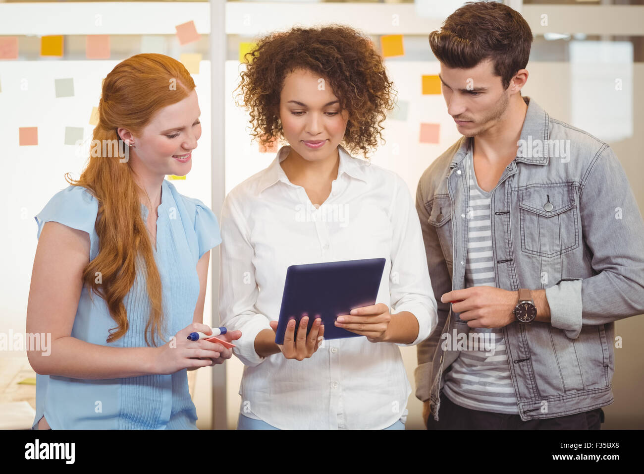 Businesswoman showing something to colleagues Stock Photo