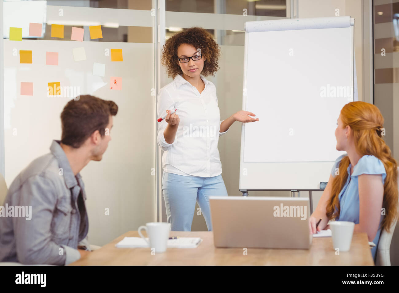 Businesswoman discussing with colleagues in meeting Stock Photo