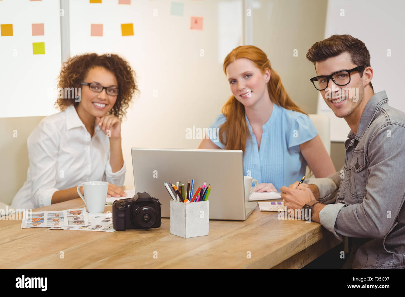 Colleagues using laptop during meeting with businesswoman Stock Photo