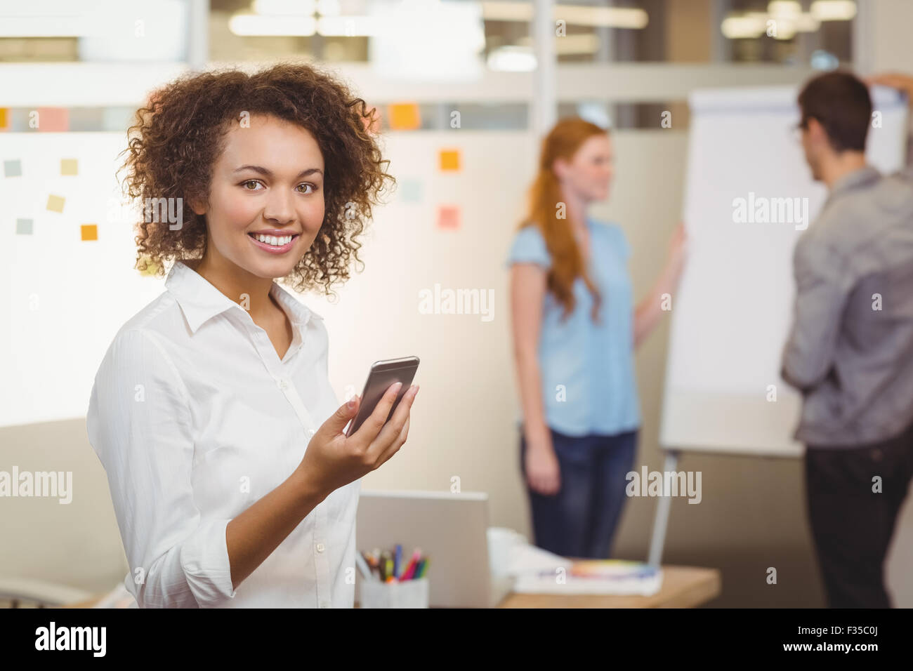 Smiling businesswoman using mobile phone Stock Photo