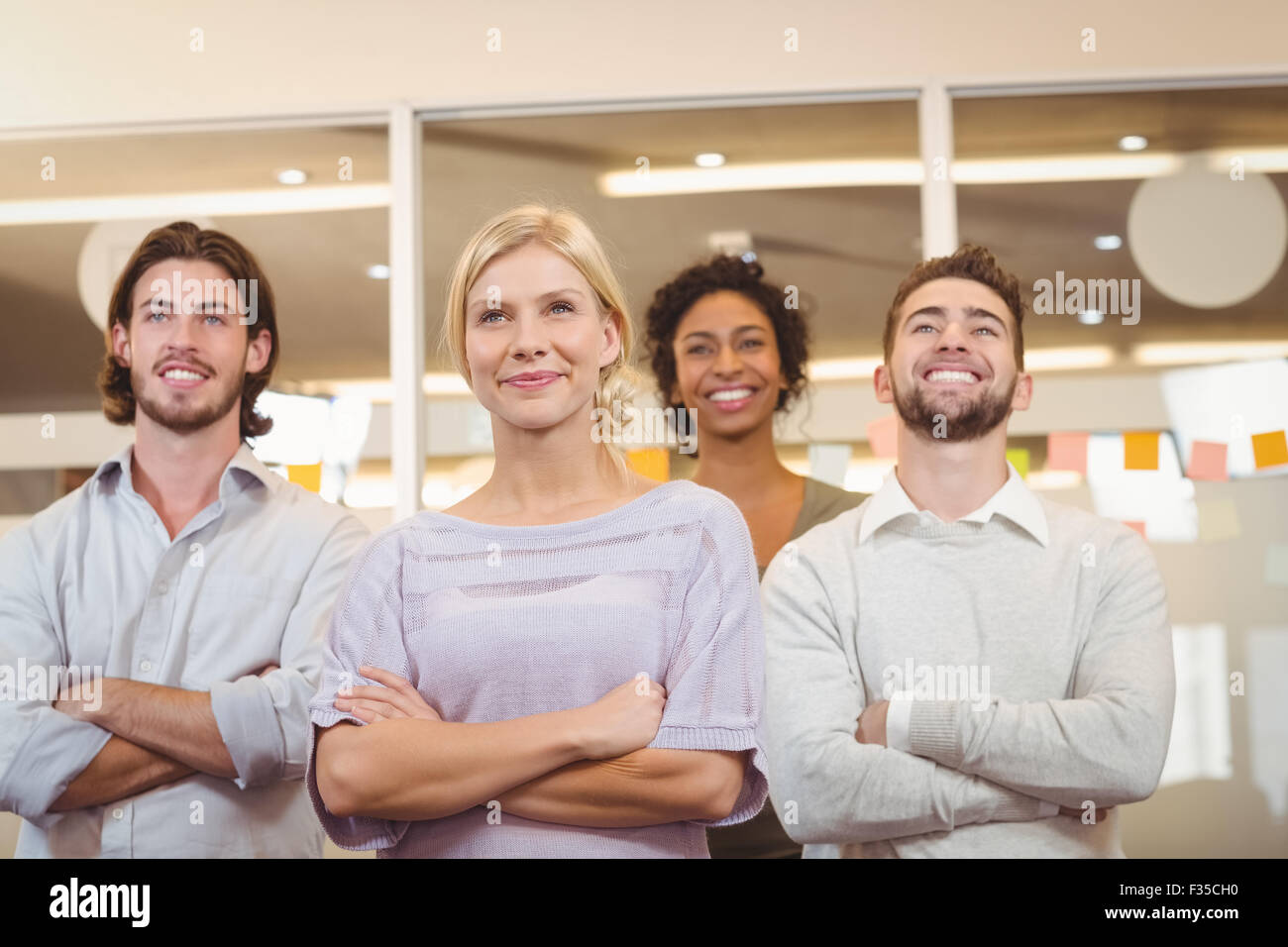 Smiling creative team with arms crossed in office Stock Photo - Alamy