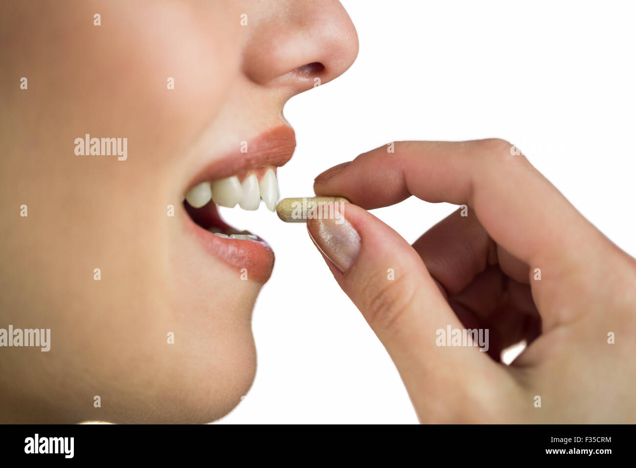 Woman taking pill on white background Stock Photo