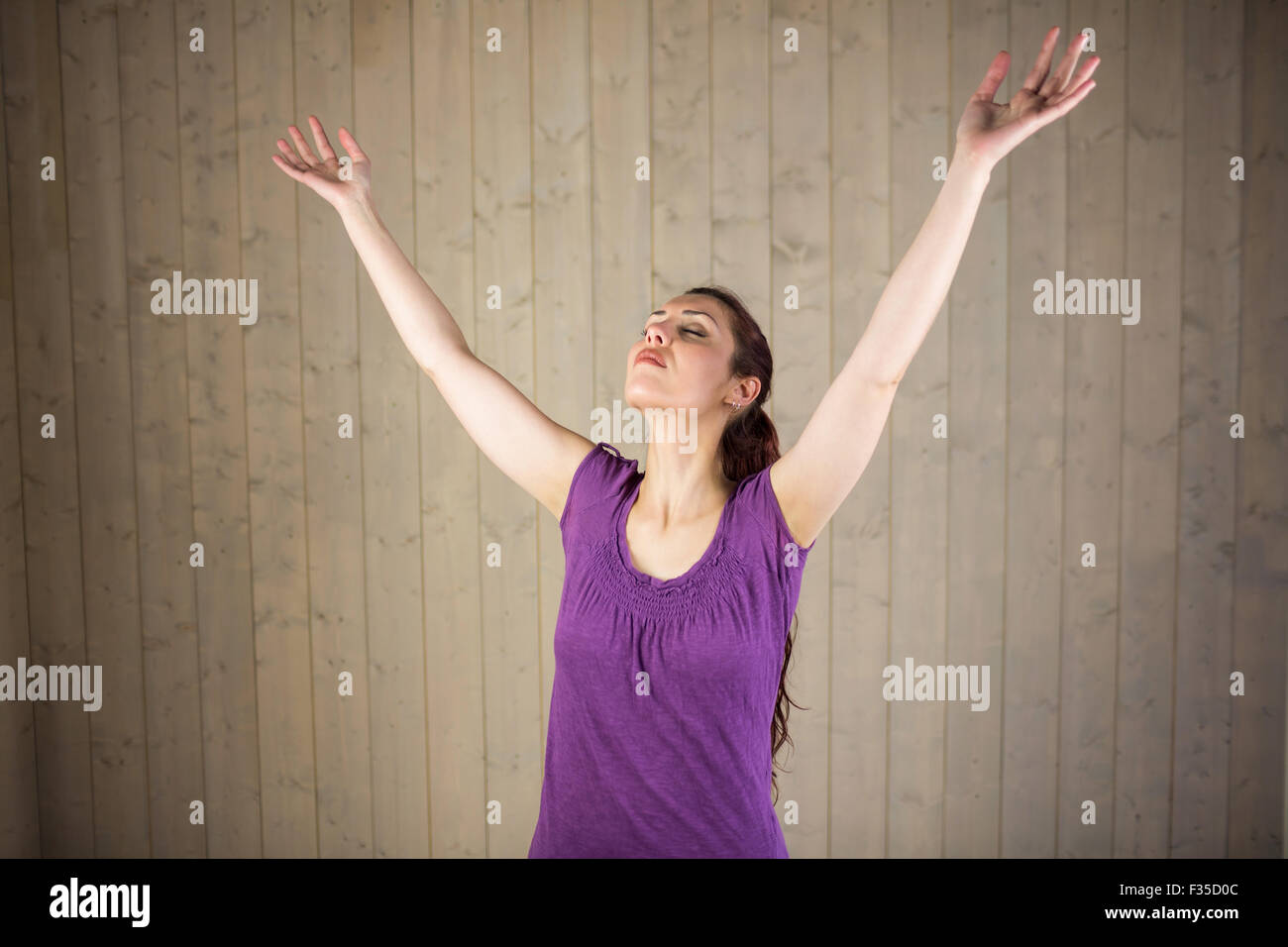Woman with arms raised and eyes closed Stock Photo